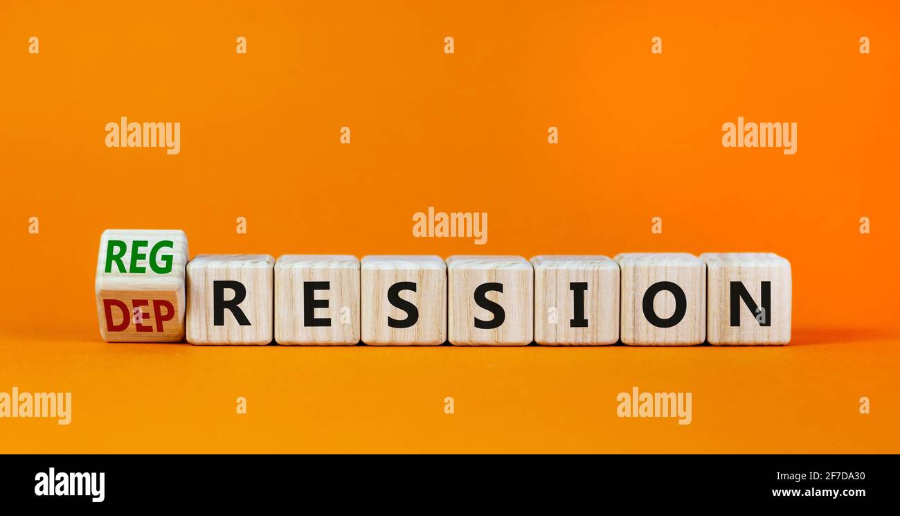 Depression or regression symbol. Turned cubes and changed the word 'depression' to 'regression'. Beautiful orange background. Psychological, depressio Stock Photo