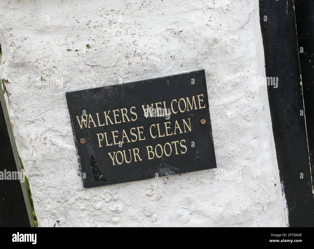 A sign saying 'Walkers welcome please clean your boots' on a pub or public house, Cheshire, England, UK Stock Photo