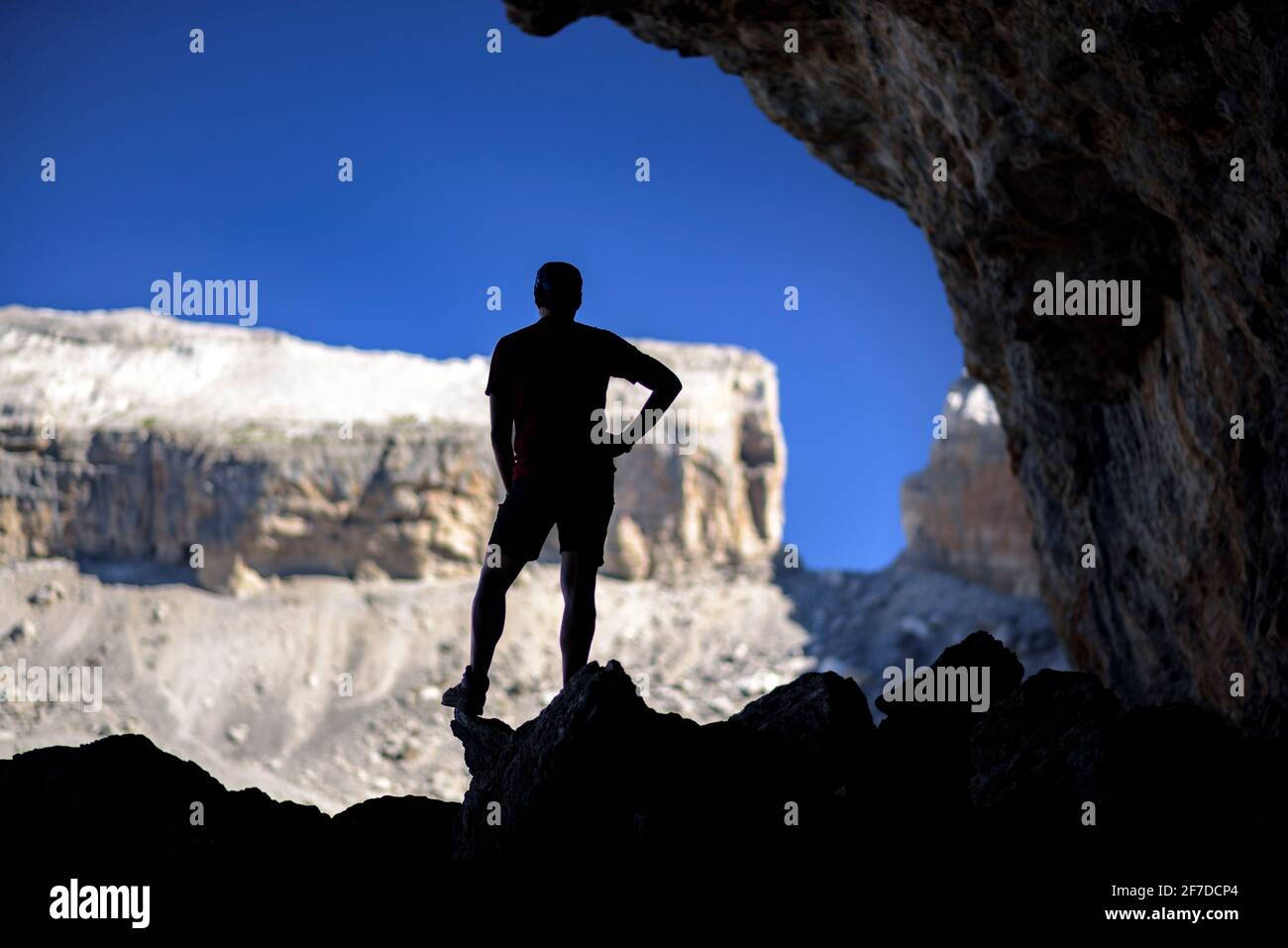 Hiker in the Casteret Cave in Ordesa and Monte Perdido National Park. The Brèche de Roland in the background (Huesca, Aragon, Spain, Pyrenees) Stock Photo