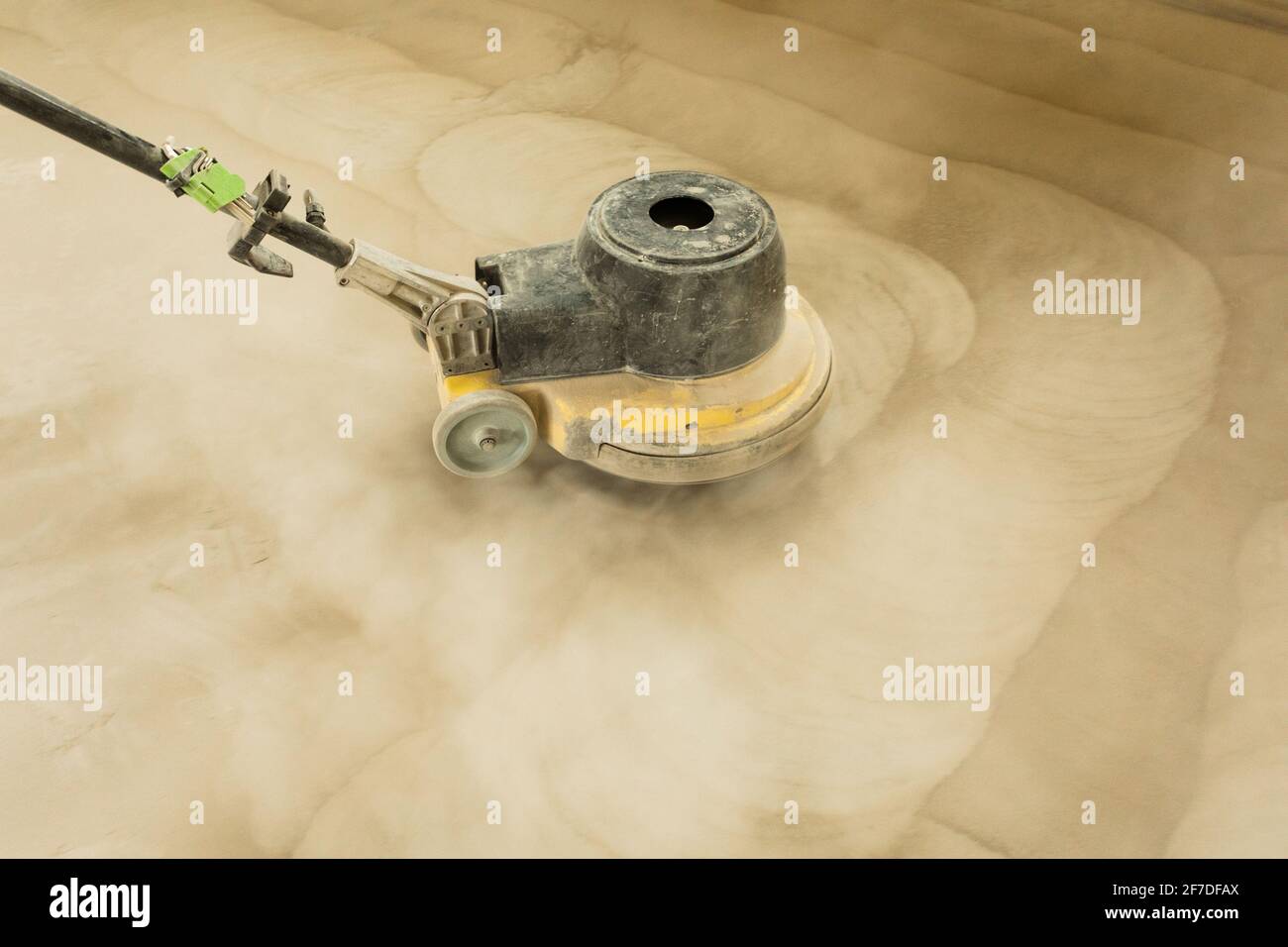A man builder grinds a concrete floor with a sander in a warehouse Stock Photo Alamy