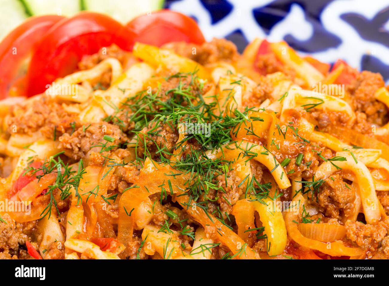 Asian style noodles with minced beef and baked vegetables. Macro. Photo can be used as a whole background. Stock Photo