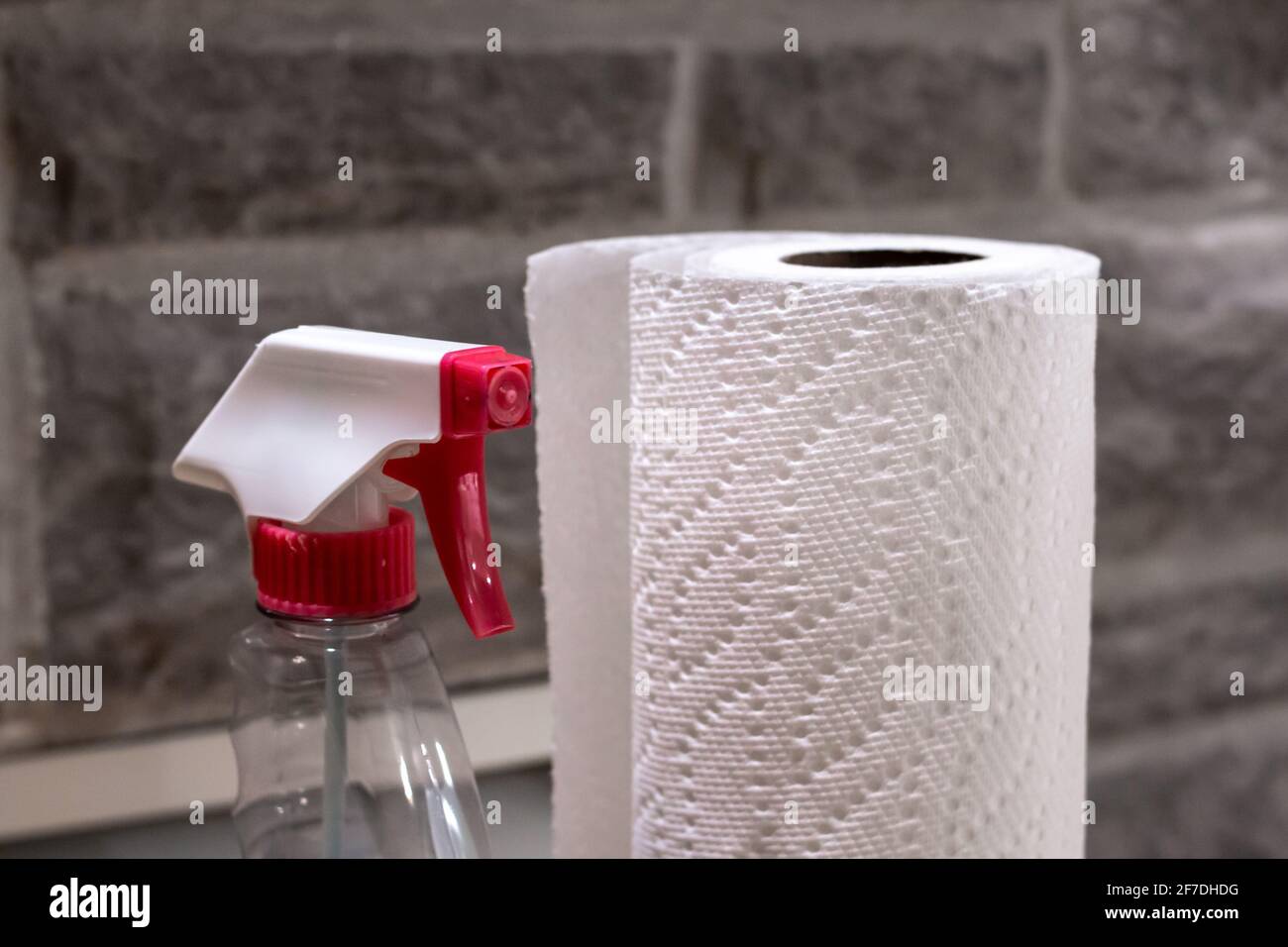 Brandless glass cleaner and a roll of paper towel against brick backdrop, Toronto, Canada, 2021. Stock Photo