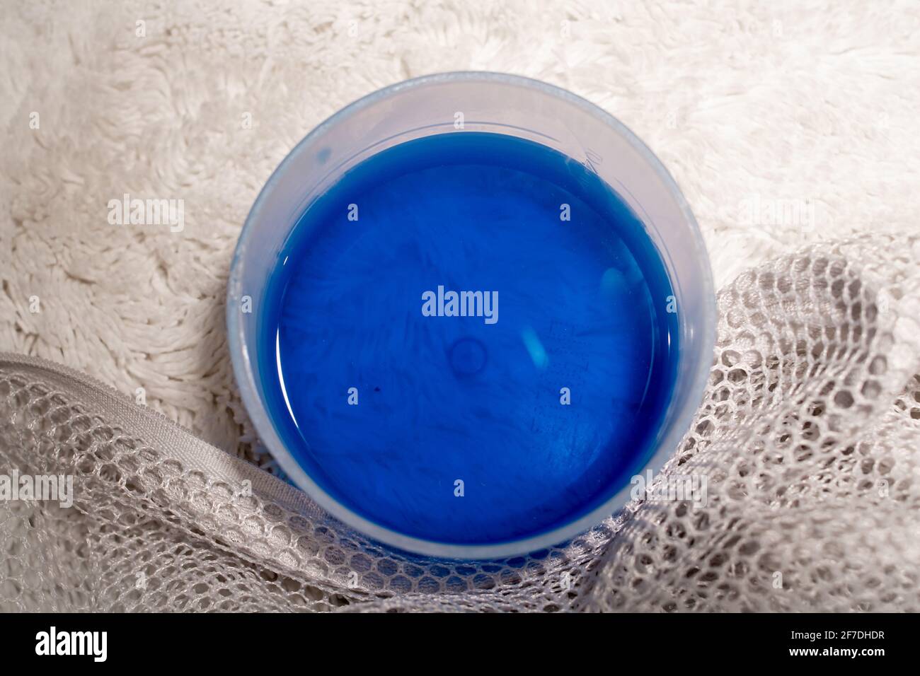 https://c8.alamy.com/comp/2F7DHDR/measuring-cup-of-laundry-detergent-and-a-mesh-laundry-bag-on-plush-white-freshly-washed-carpet-toronto-canada-2F7DHDR.jpg