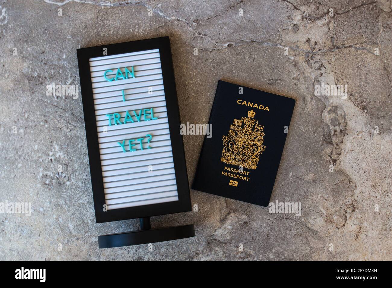 Message board, 'can I travel yet' and Canadian passport on a marble backdrop, Canada, Ontario. Stock Photo