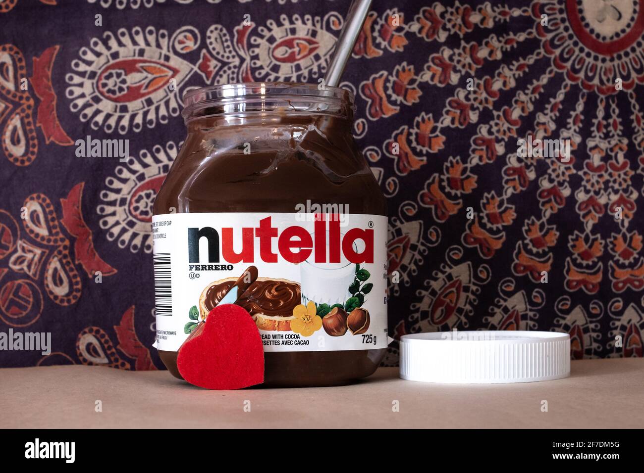 Toronto, Ontario, Canada - February 4 2021: A jar of Nutella, a hazel nut spread, in front of a mandala tapestry. February 5 2021 is World Nutella Day. Stock Photo