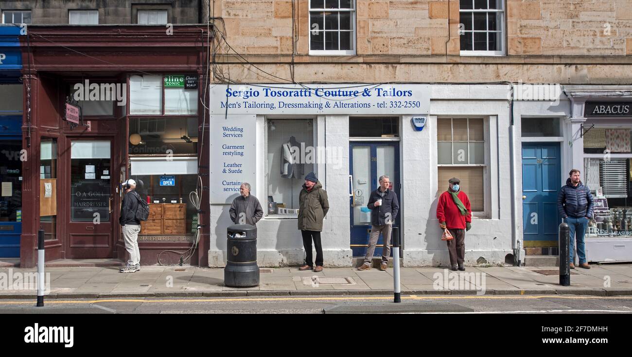 Men queueing outside a barber's shop on the 5th April 2021 when they'd just reopened after the second covid lockdown. Edinburgh, Scotland, UK. Stock Photo