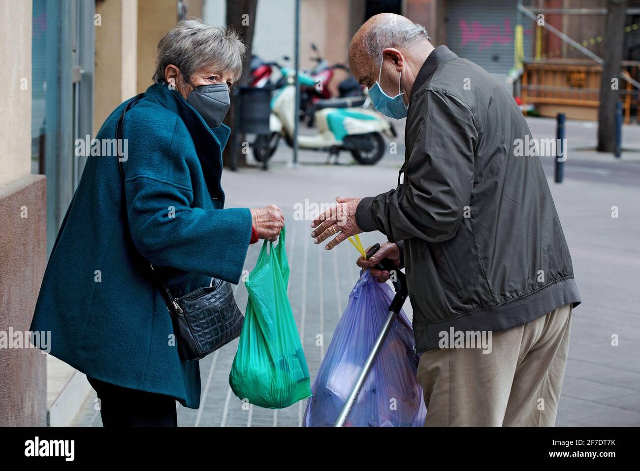 Old Catalan couple taking the rubbish out. Stock Photo