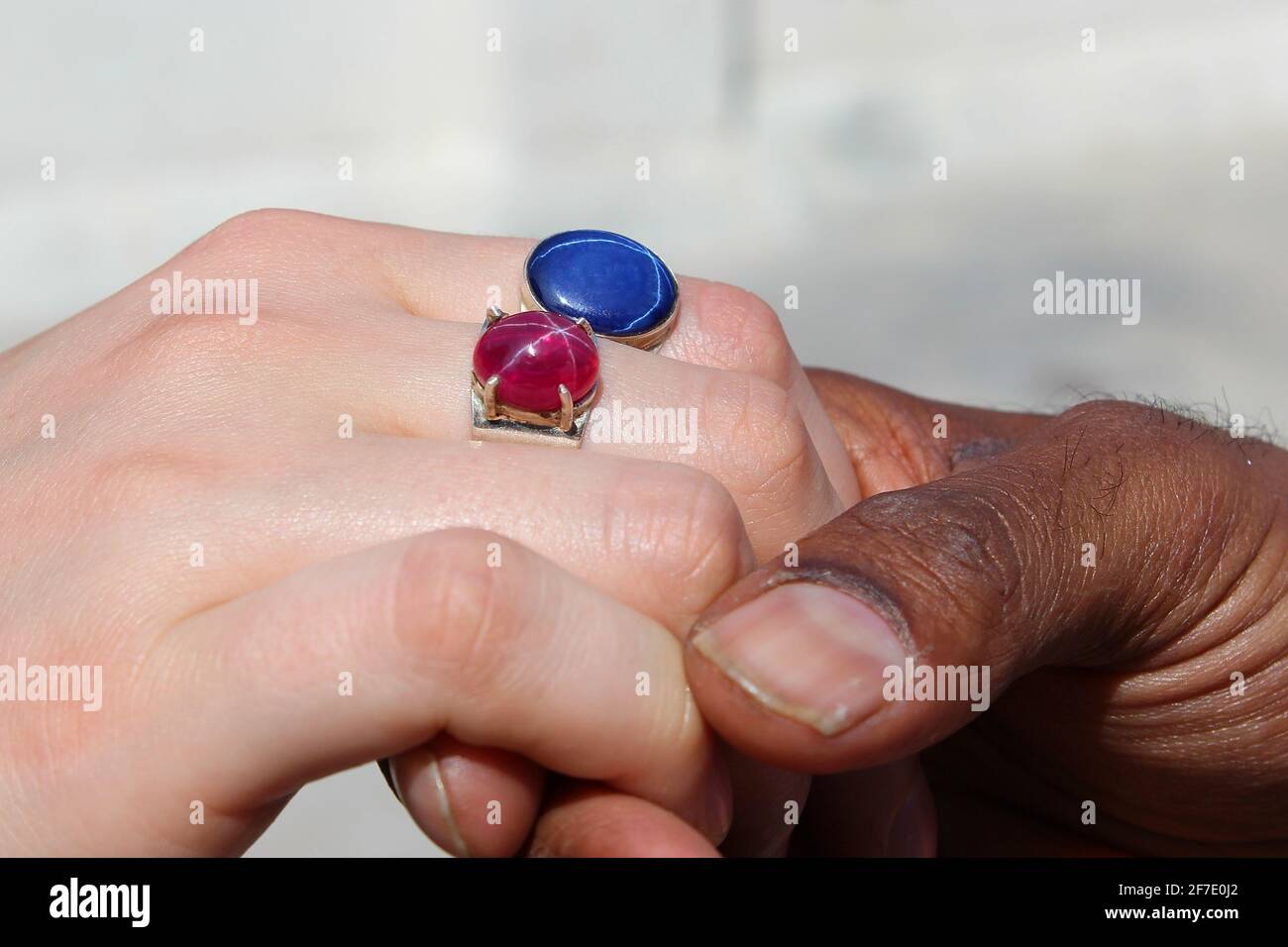 Men and women hands with red and blue gemstones (India) Stock Photo