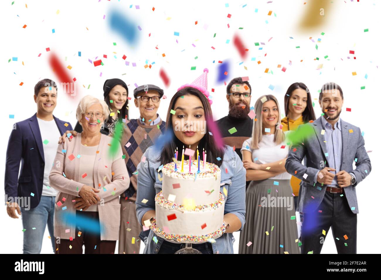 Young woman celebrating birthday and blowing candles on a cake with her family isolated on white background Stock Photo