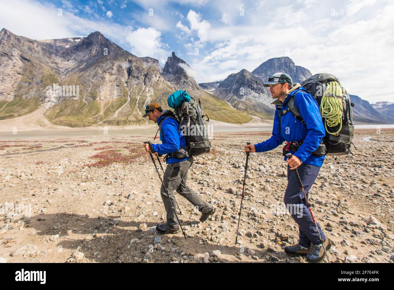 Side view of backpackers hiking in a mountain valley. Stock Photo