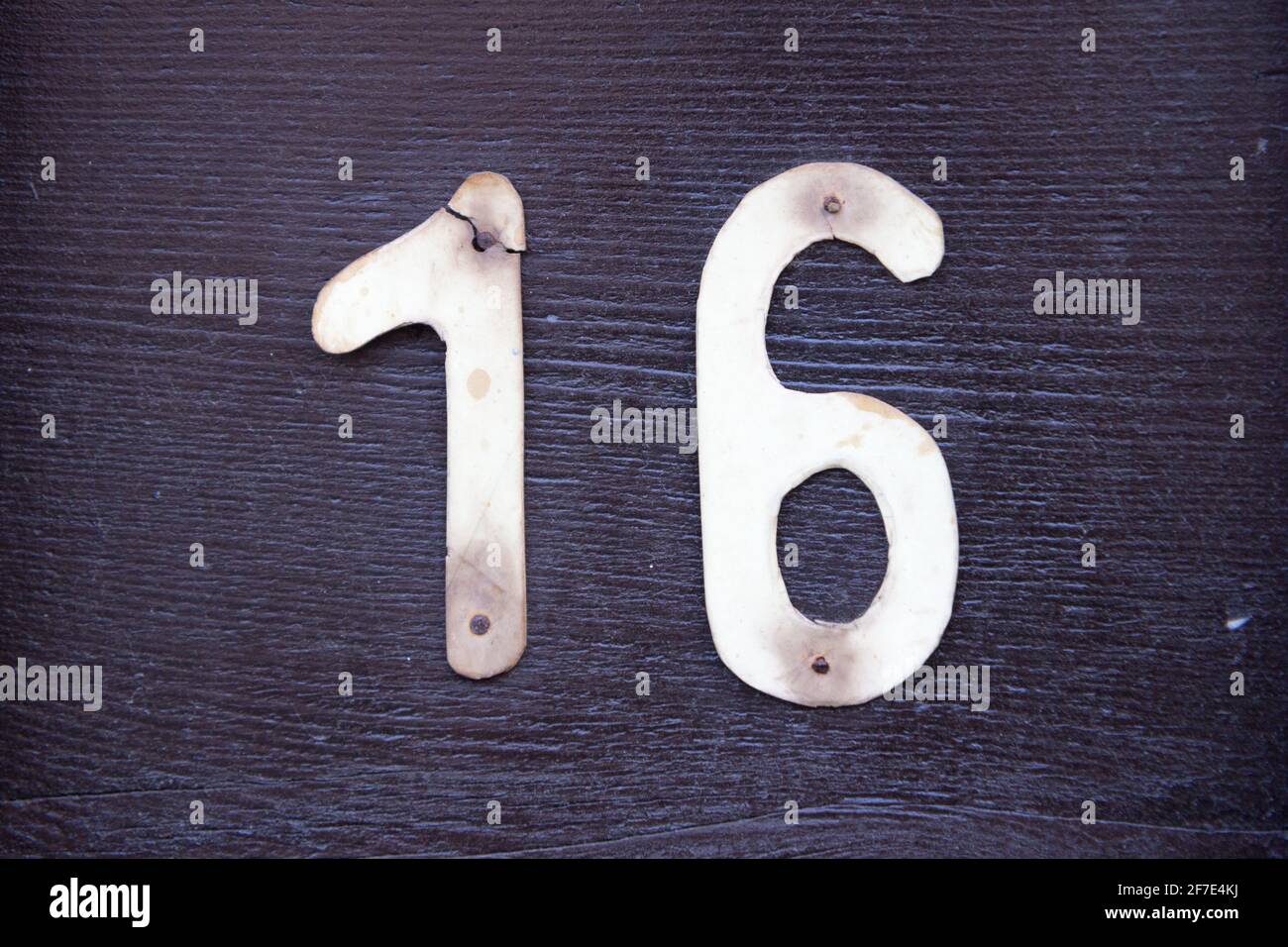 Number 16 in plastic screwed on wood Stock Photo