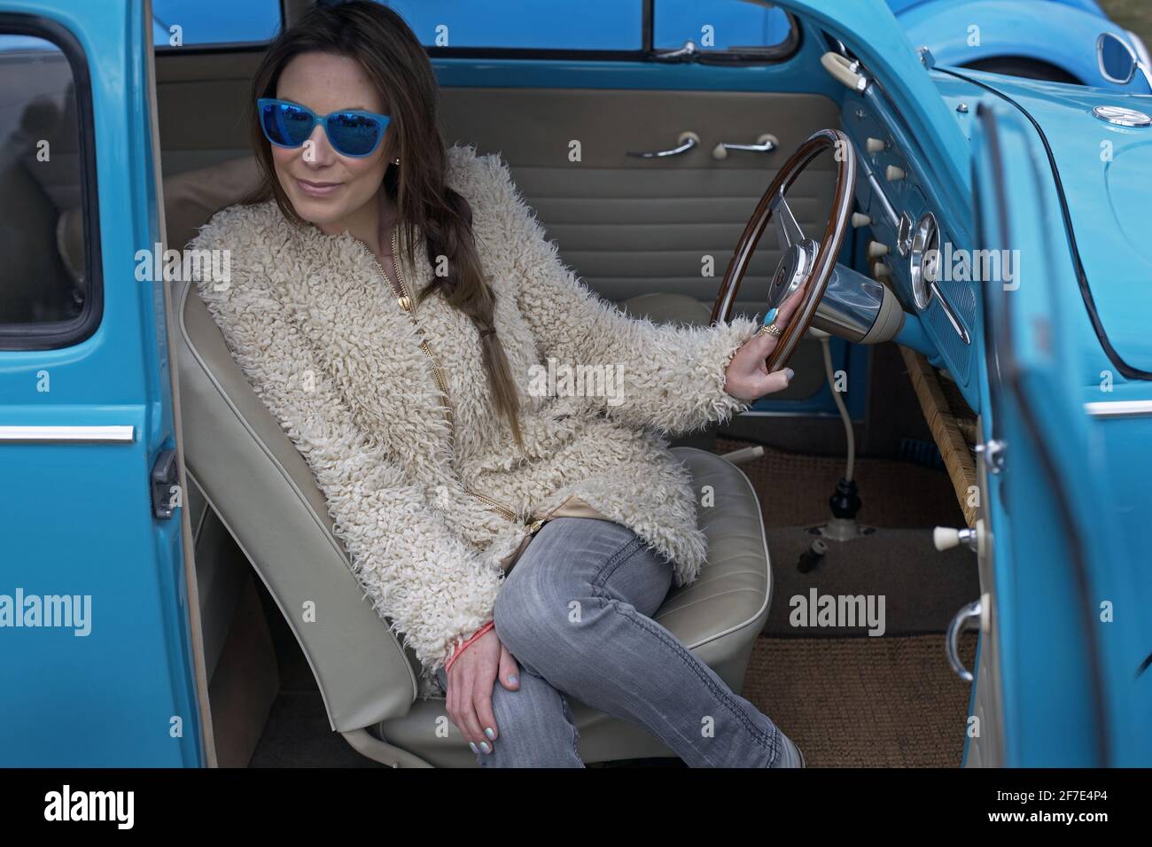 GREAT BRITAIN / England /Young woman with blue sunglasses sitting in 1961 Volkswagen . Stock Photo
