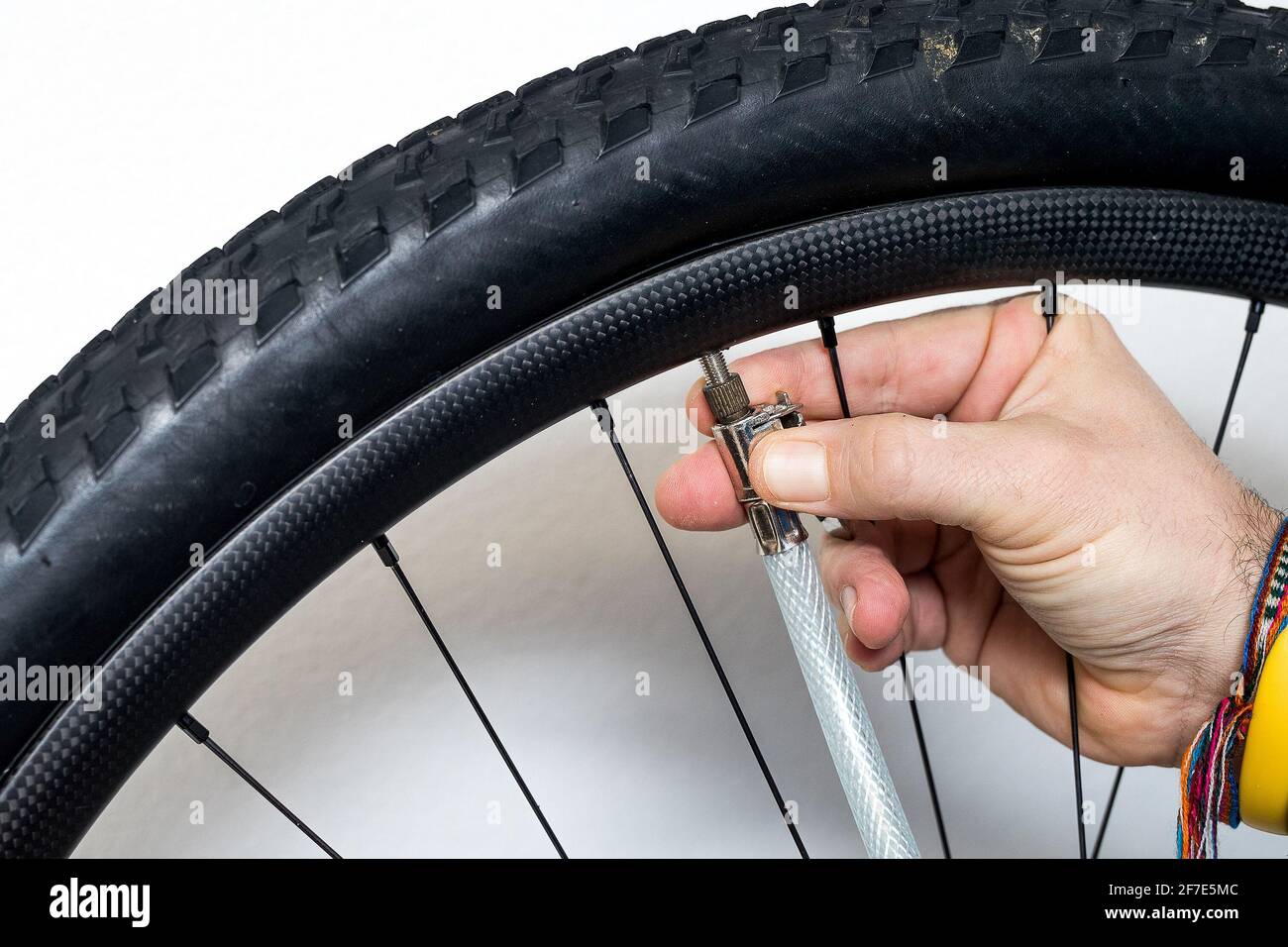 A person is inflating a bicycle wheel with the help of compressed air