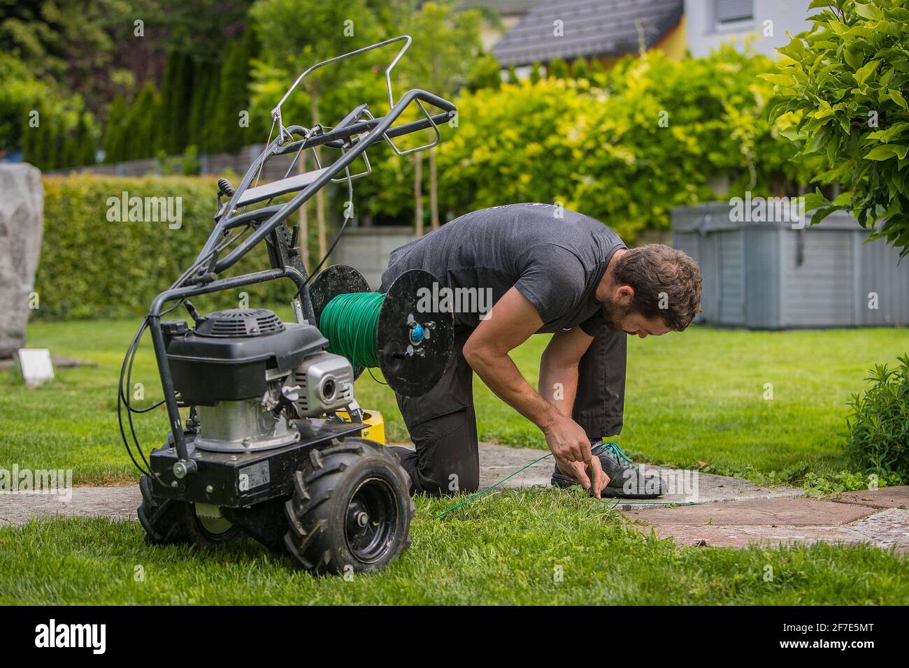 https://c8.alamy.com/comp/2F7E5MT/cable-laying-machine-with-an-operator-used-to-put-down-cables-for-robotic-lawnmowers-inserting-cable-in-the-ground-as-a-guide-cable-for-robotic-lawnm-2F7E5MT.jpg