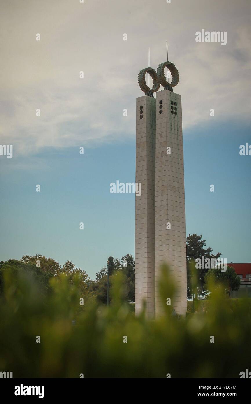Monument of Carnation revolution in Lisbon, an obelisk in the park of Eduardo VII in Lisbona, Portugal. Towers rising from green grass in the park. Stock Photo