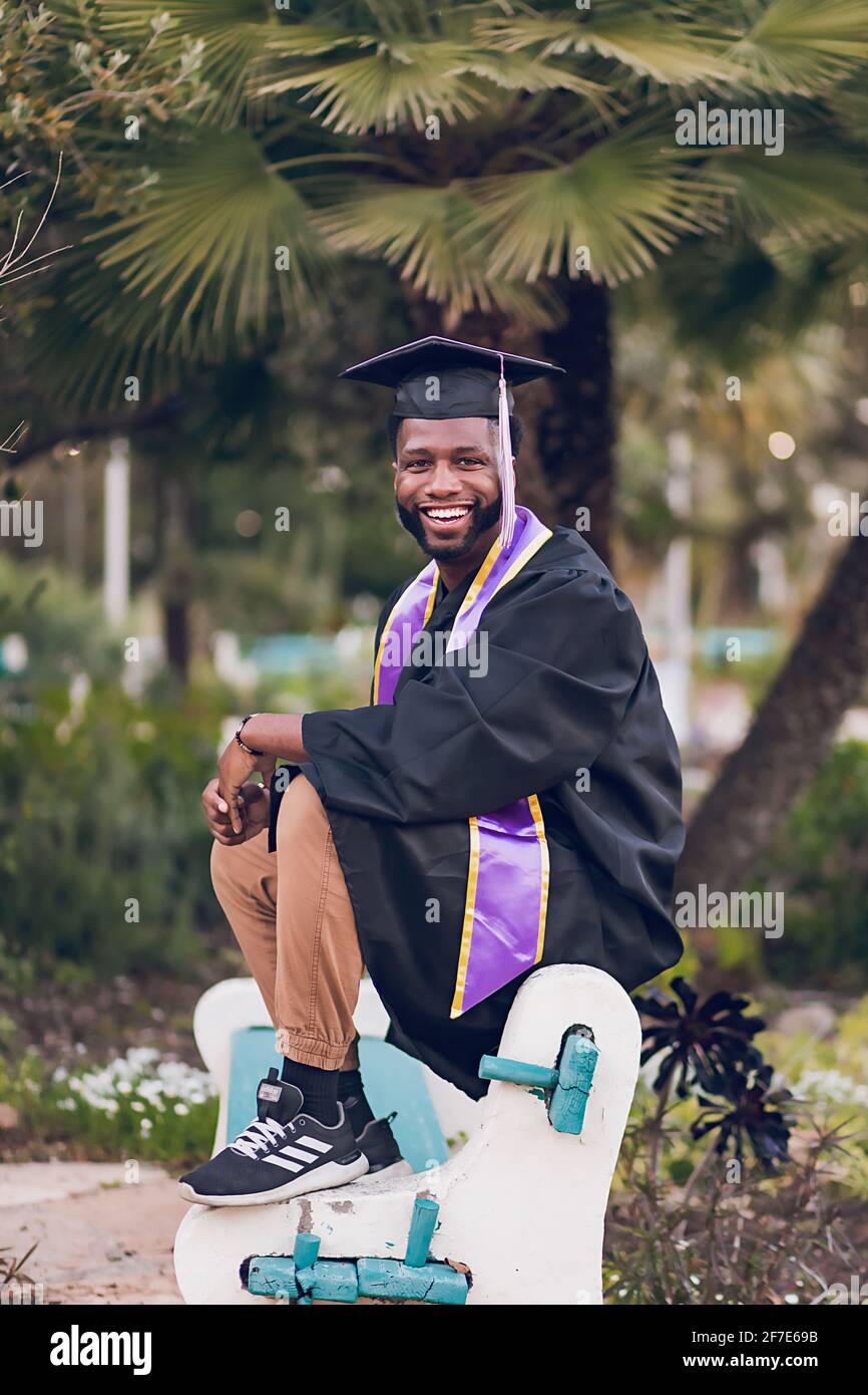 Happy to be graduating college, man wearing a graduation gown/cap. Stock Photo