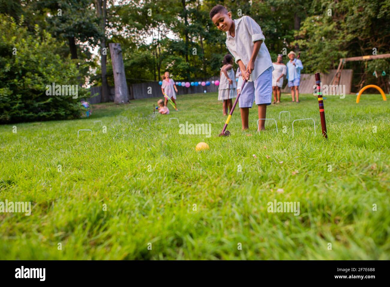 Young boy playing cricket or croquet Stock Photo Alamy