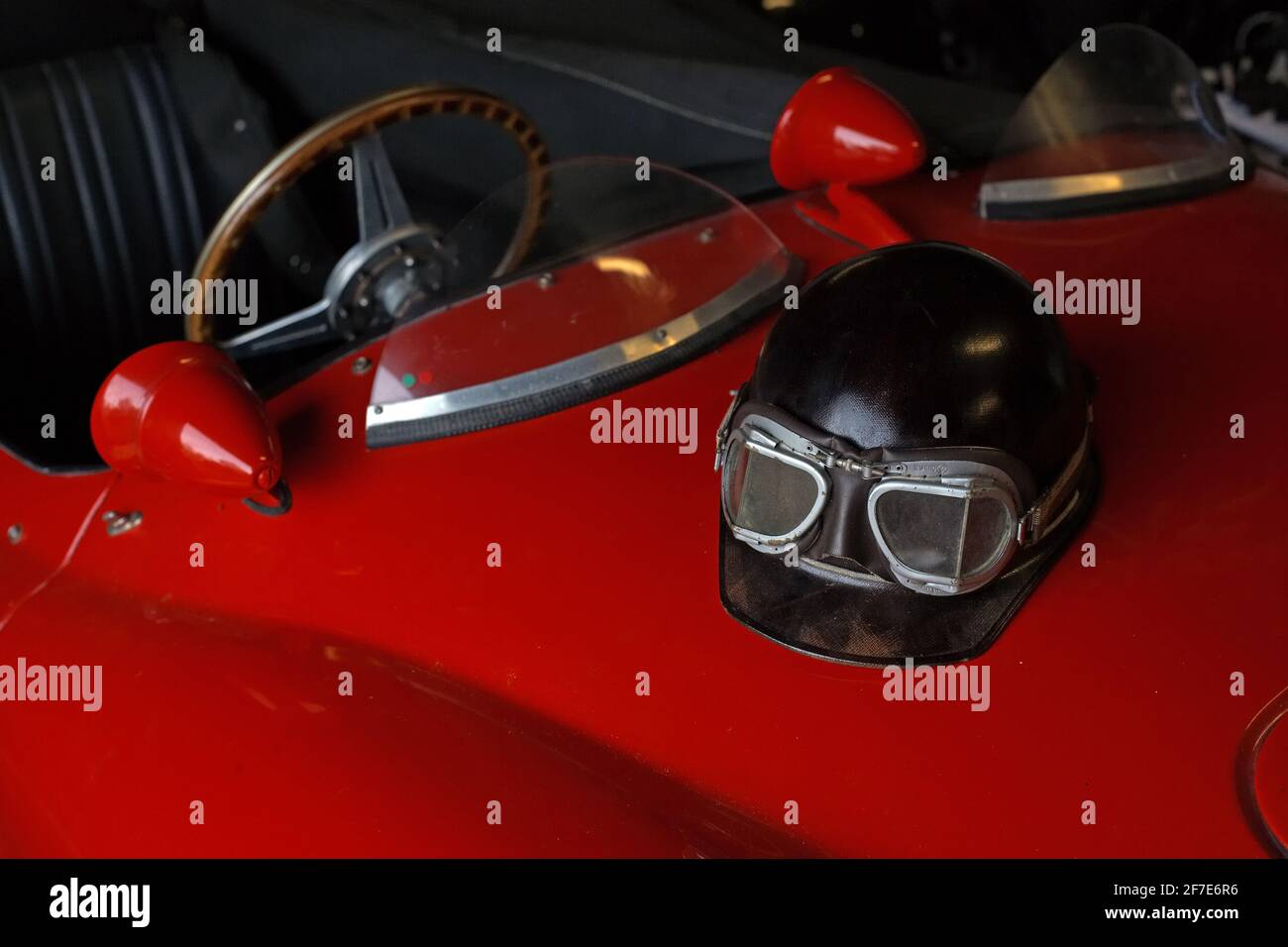 Helmet on car hood . Vintage helmet on classic car bonnet . Stock Photo