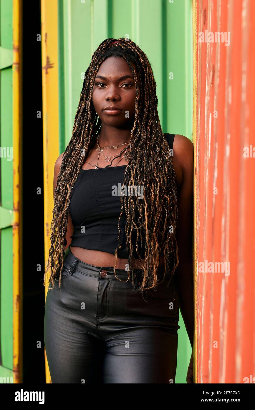Black woman with braids and urban clothes looks serious at the camera Stock Photo