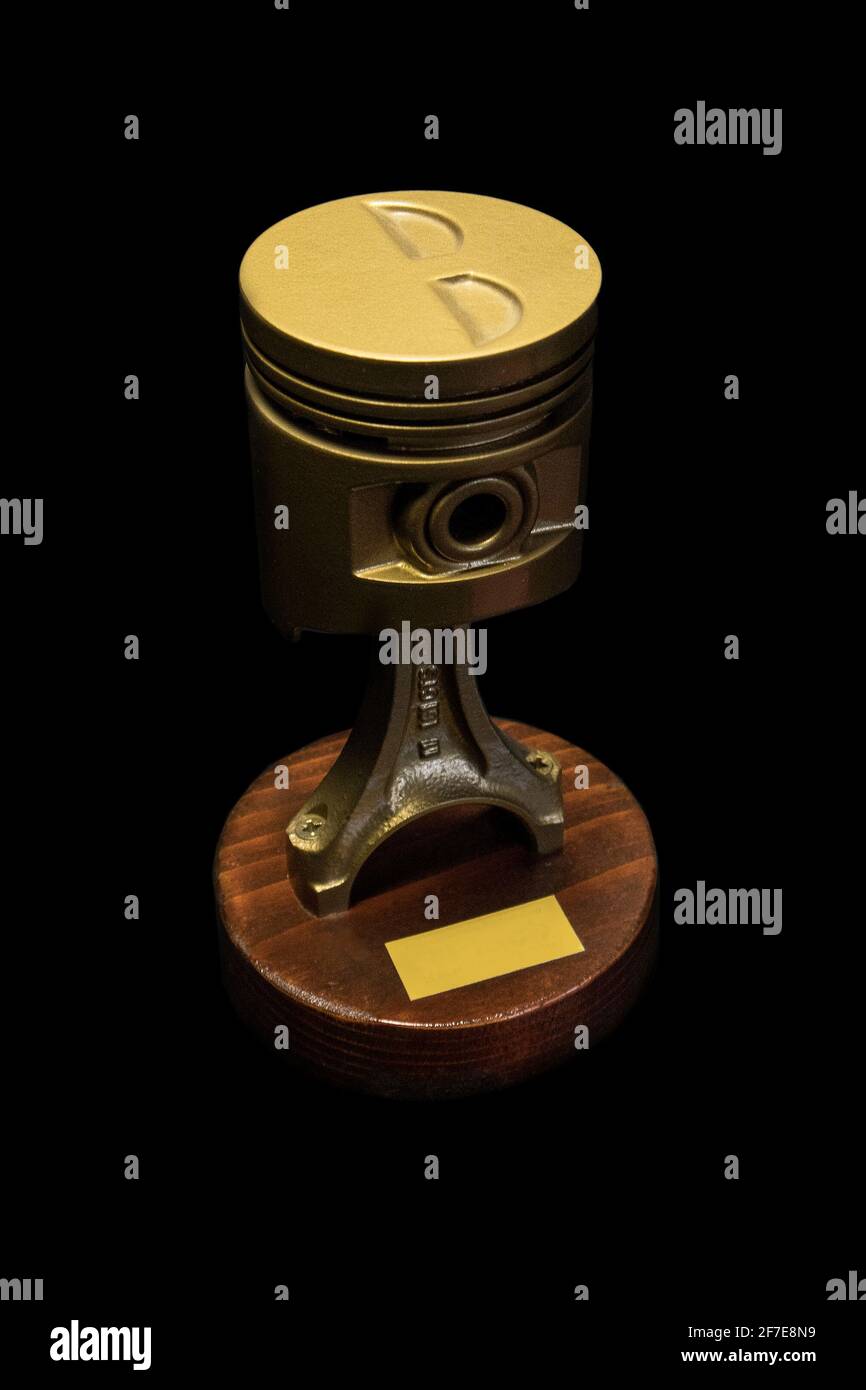 A golden piston on a wooden base, used as a prize or a victory cup. Gold,  base plate for dark wood. Isolated on black Stock Photo - Alamy