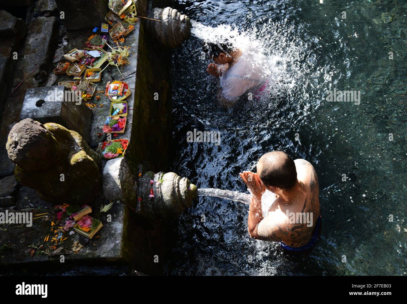 Balinese people purifying themselves at the purifying bath at the Tirta Empul temple in Bali, Indonesia. Stock Photo