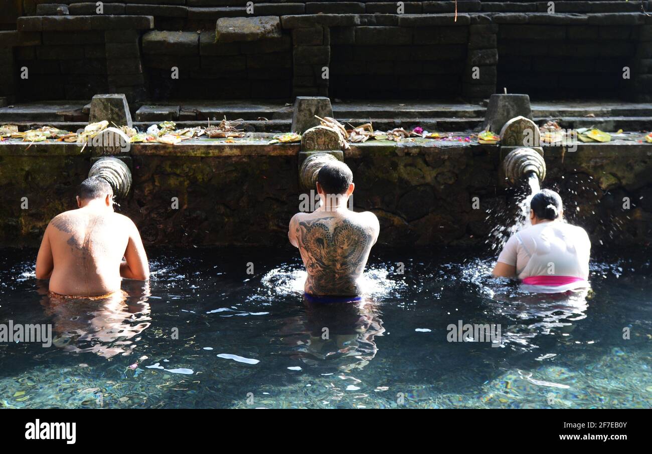 Balinese people purifying themselves at the purifying bath at the Tirta Empul temple in Bali, Indonesia. Stock Photo