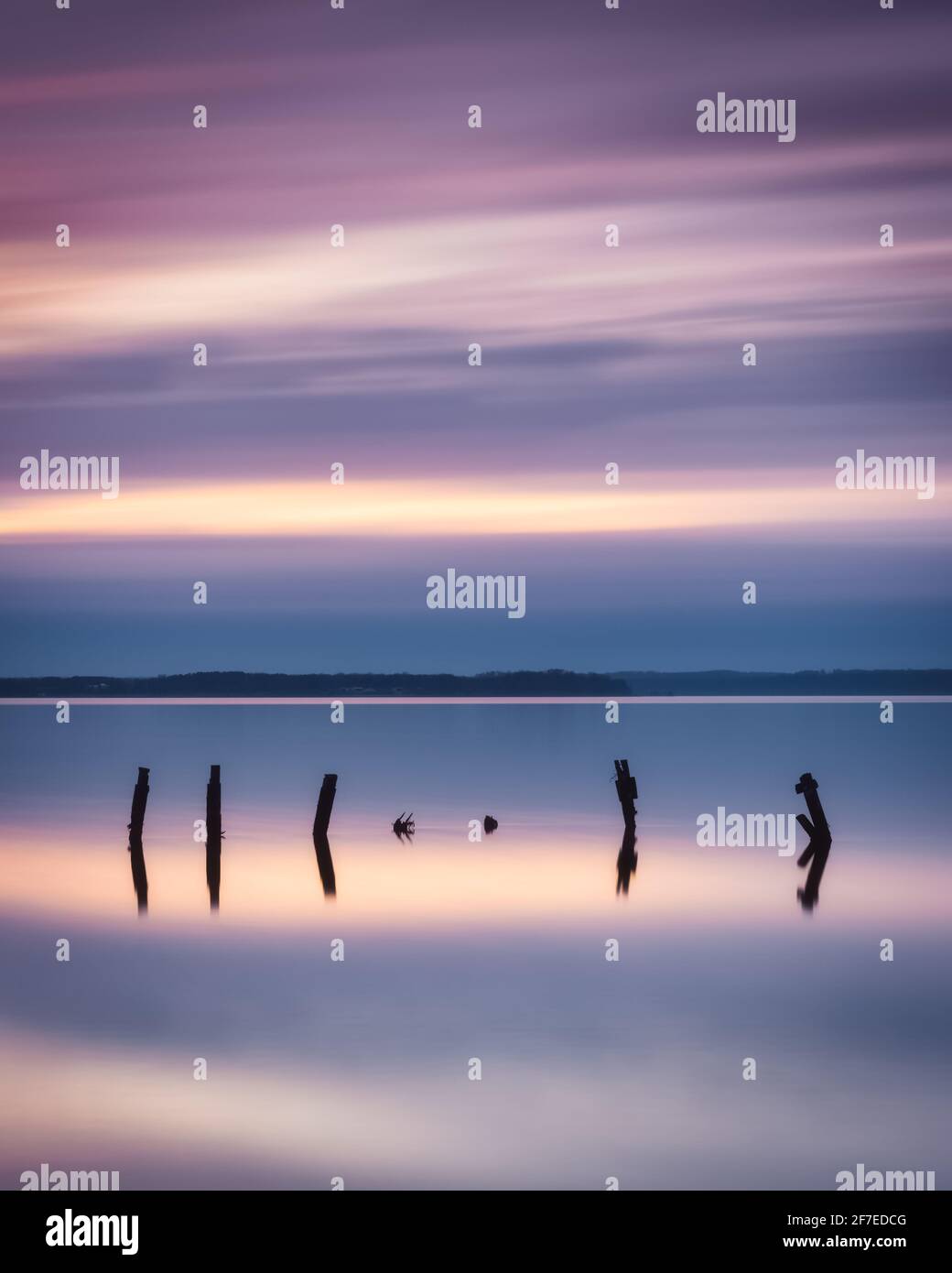 A colorful, pastel long exposure photograph of broken pieces of a jetty in the Potomac River at Leesylvania State Park. Stock Photo