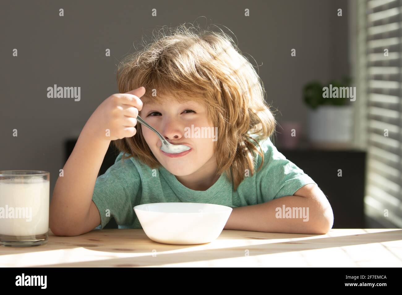 Child eat. Little healthy hungry boy eating soup from with spoon. Stock Photo