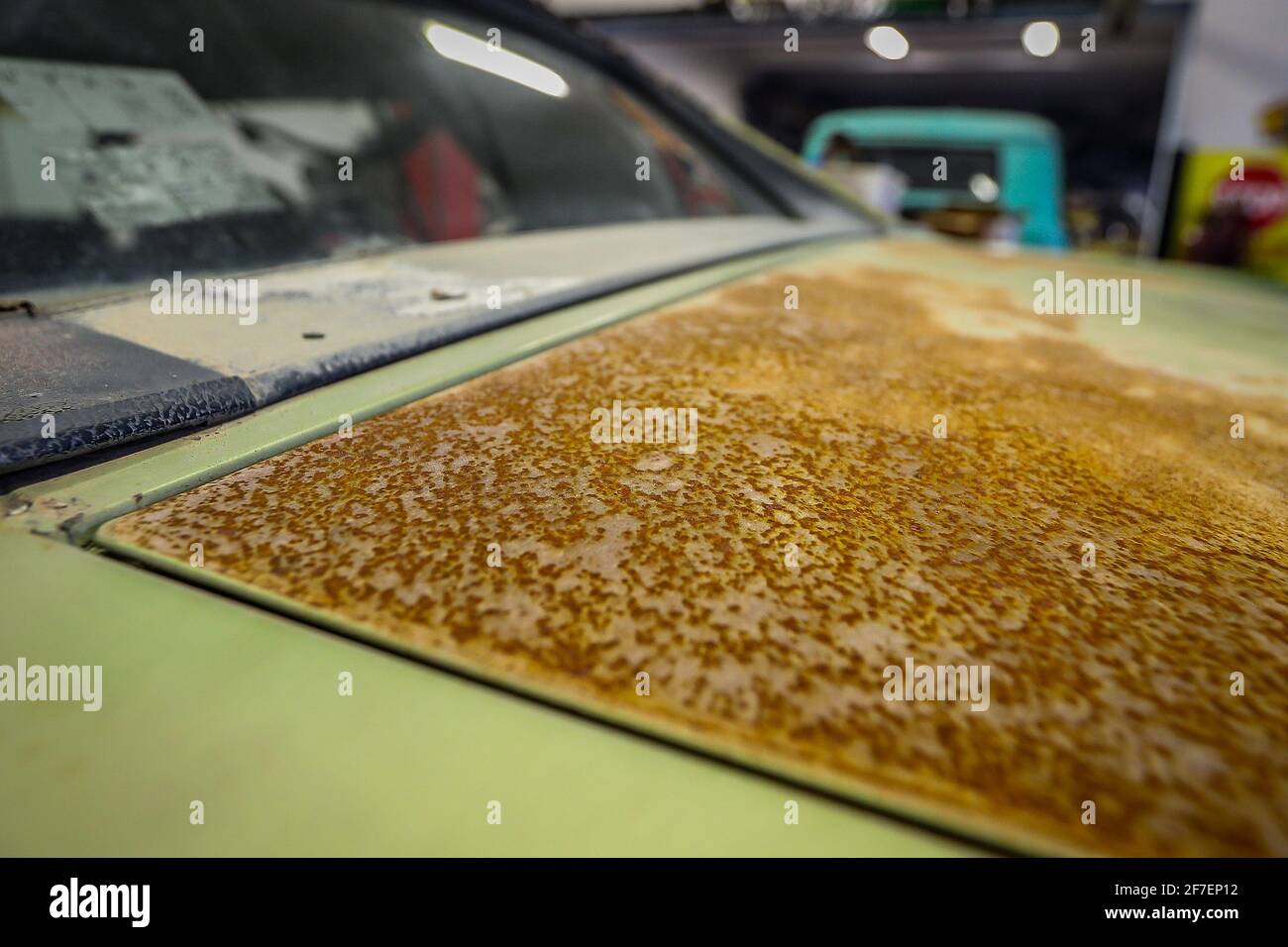 Heavily rusted surface of a vintage american lime green muscle car in a ...