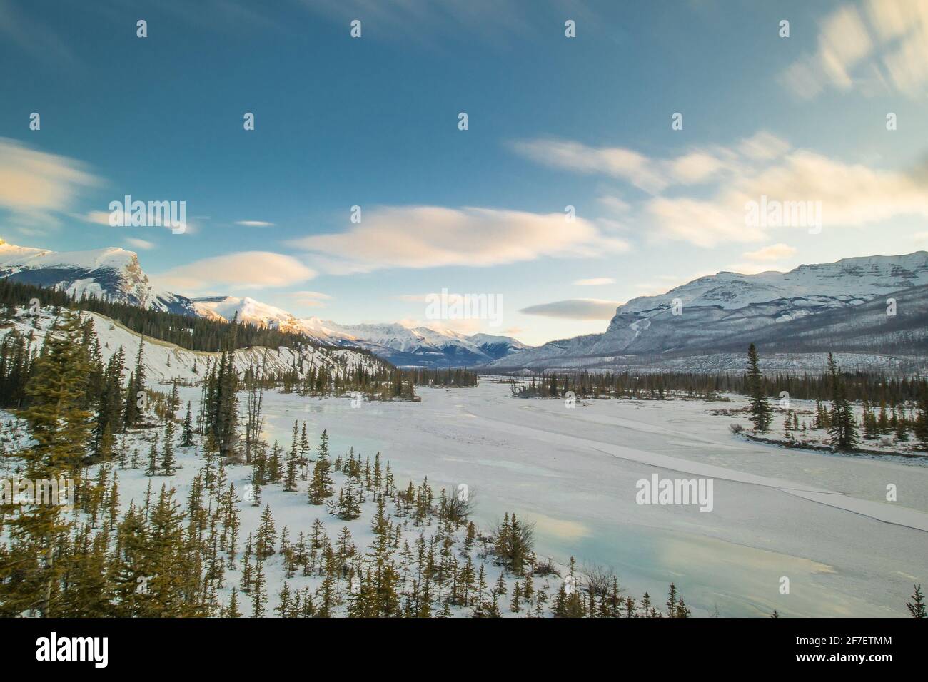 View from the bridge at Saskatchewan river crossing in early morning winter hours. Sun just rising behind the hills, frozen river seen in the foregrou Stock Photo