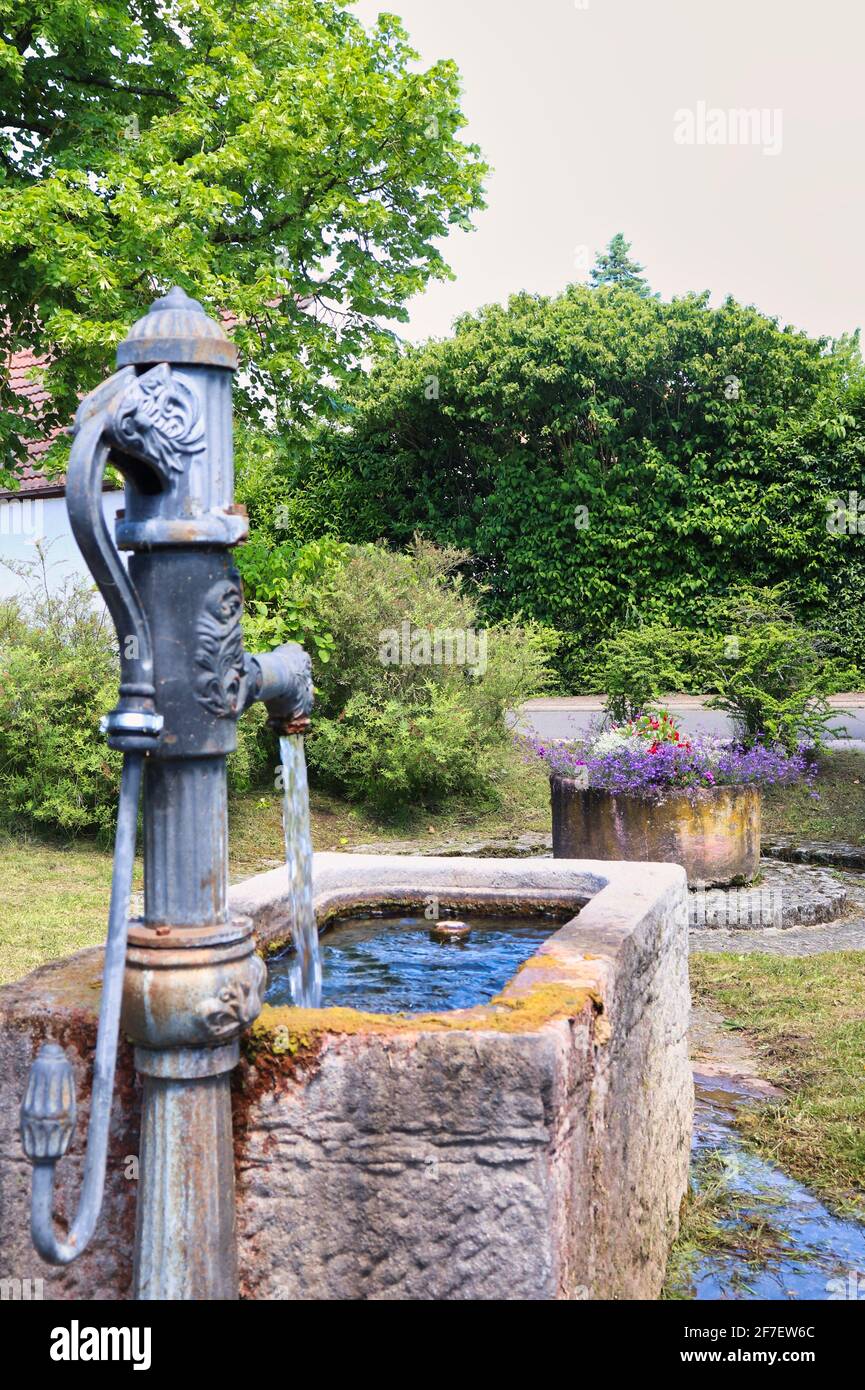 Back of a decorative water pump with running water at a park in