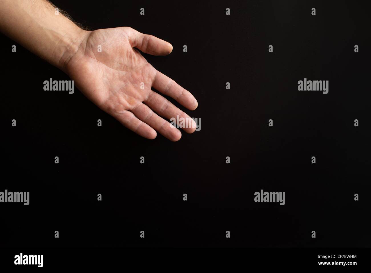 a man's hand on a black background.  Stock Photo