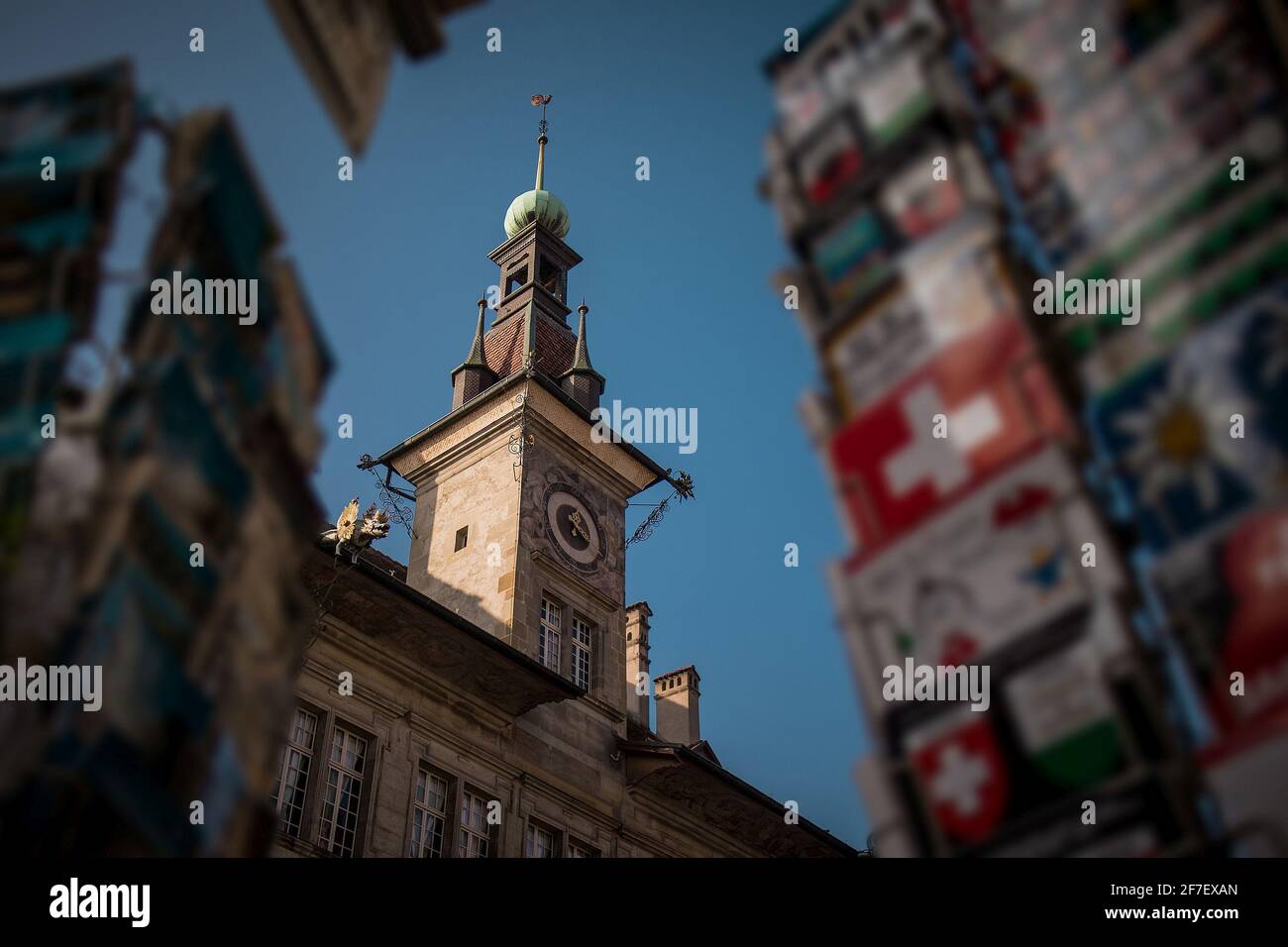 Detail of Lausanne City hall clock tower in early afternoon, looking through the swiss vintage postcards in the foreground. Stock Photo