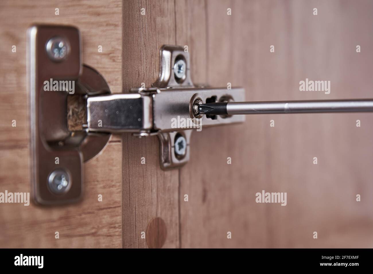 Srewdriver fixing kitchen cabinet door, close up Stock Photo