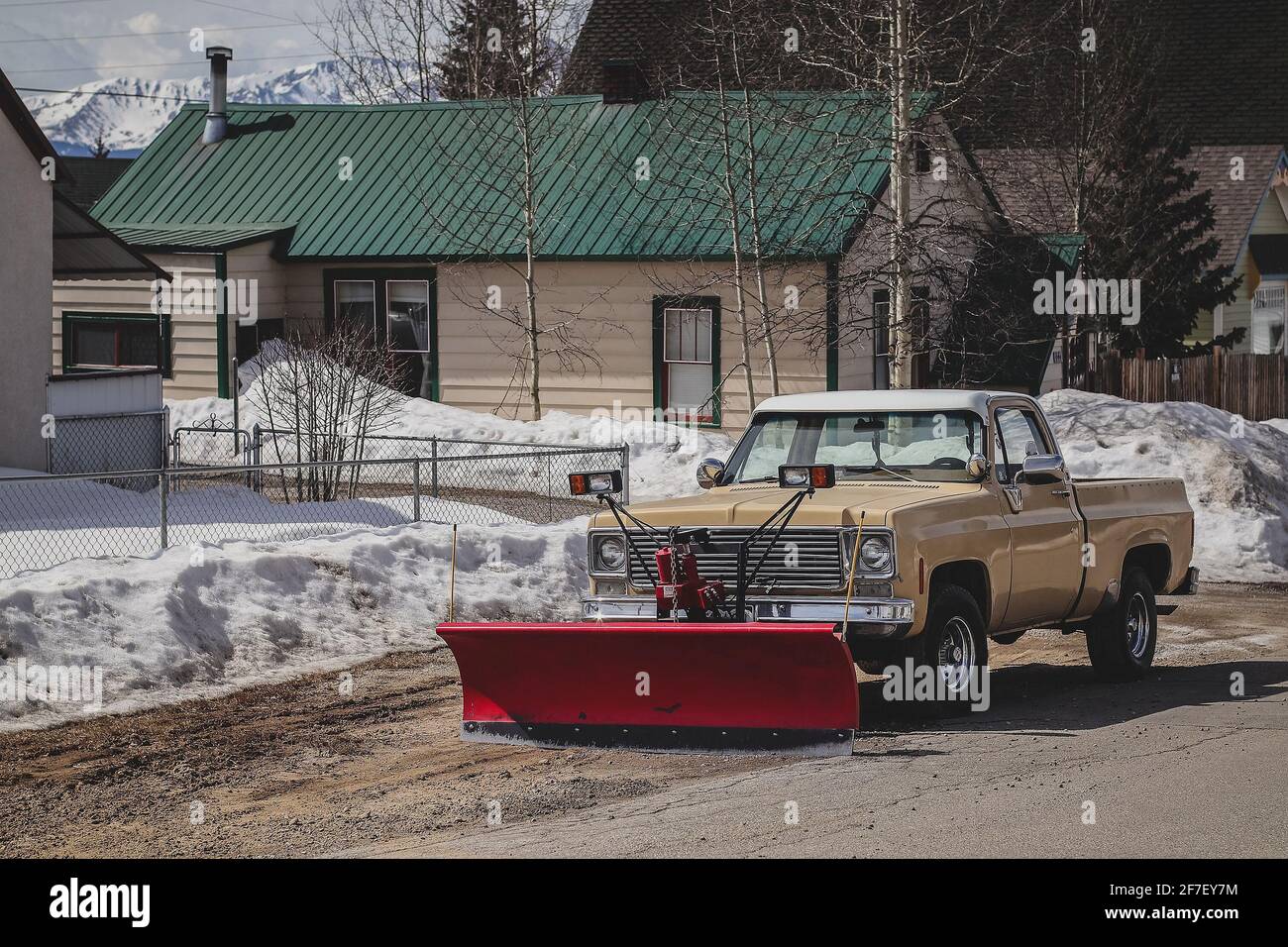 An older pickup car with a red snow plow mounted on the front Stock Photo Alamy
