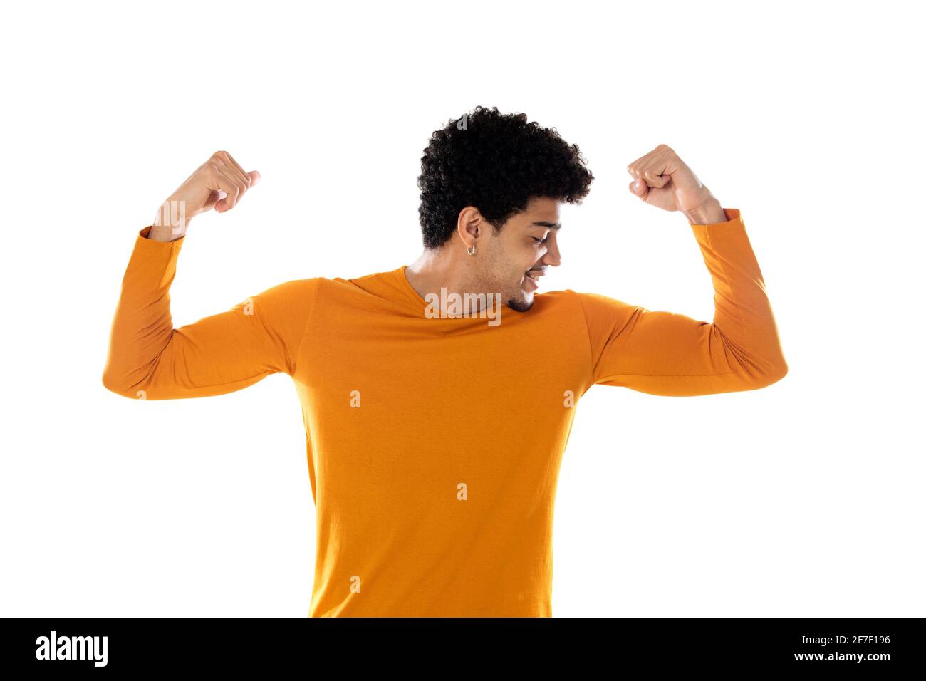 Young african american black man feeling happy, satisfied and powerful, flexing fit and muscular biceps, looking strong after the gym against isolated Stock Photo