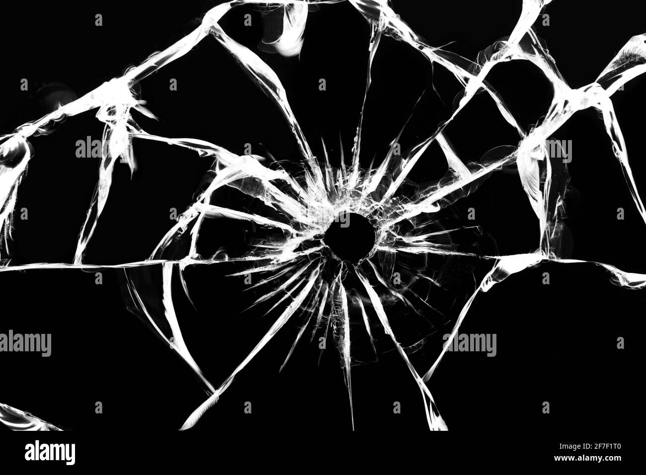 Damaged glass with cracks, cracks in the glass from the shot. Broken window, texture on a black background Stock Photo