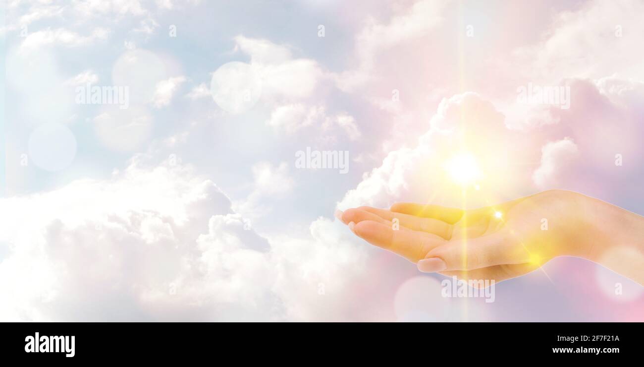 Abstract background of hand holding sun over sky background. Stock Photo
