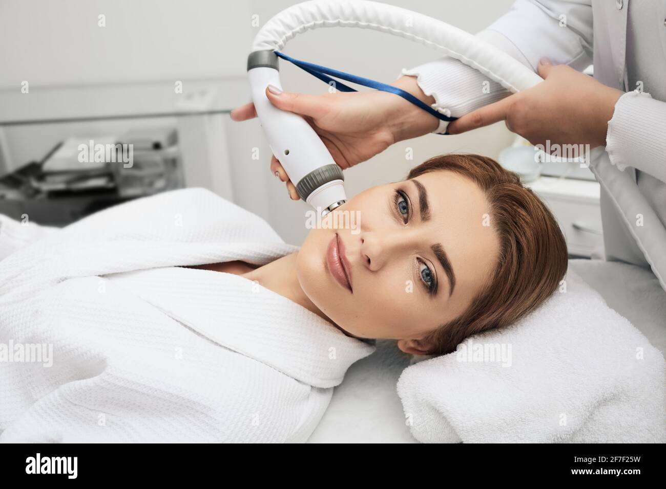 Cosmetologist doing an acoustic wave therapy for woman's face. Skin rejuvenation with acoustic waves, close-up Stock Photo
