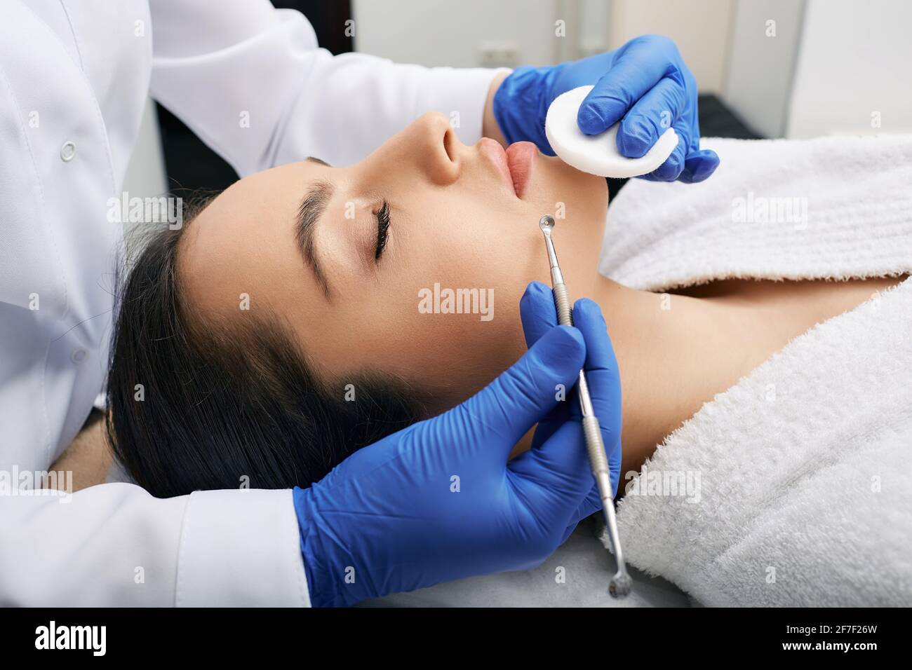 Facial cleansing. Beautiful woman having mechanical cleansing face skin from defect and remove blackhead Stock Photo