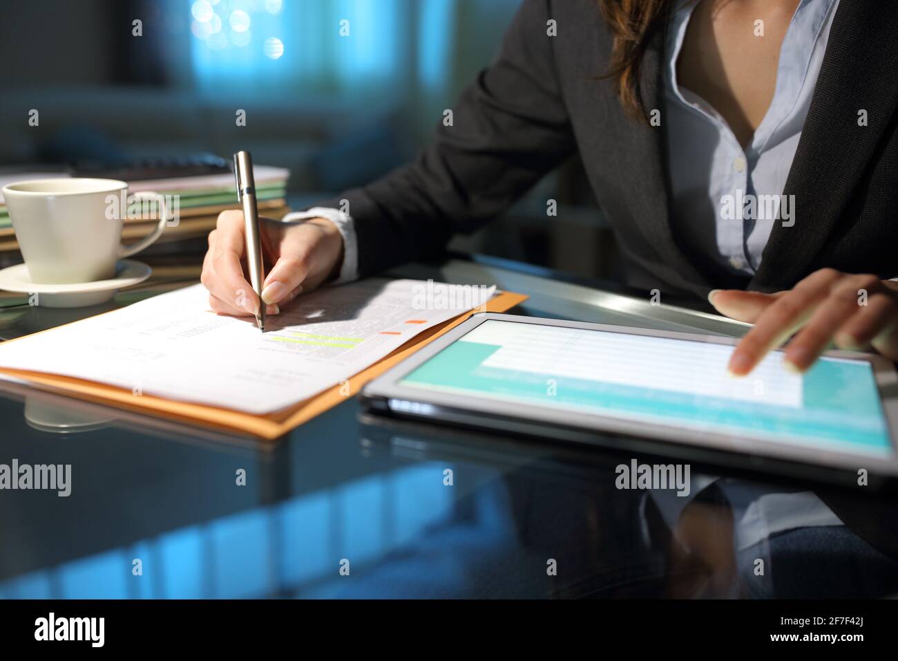 Close up ofn entrepreneur hands comparing paper form with tablet online content at homeoffice Stock Photo