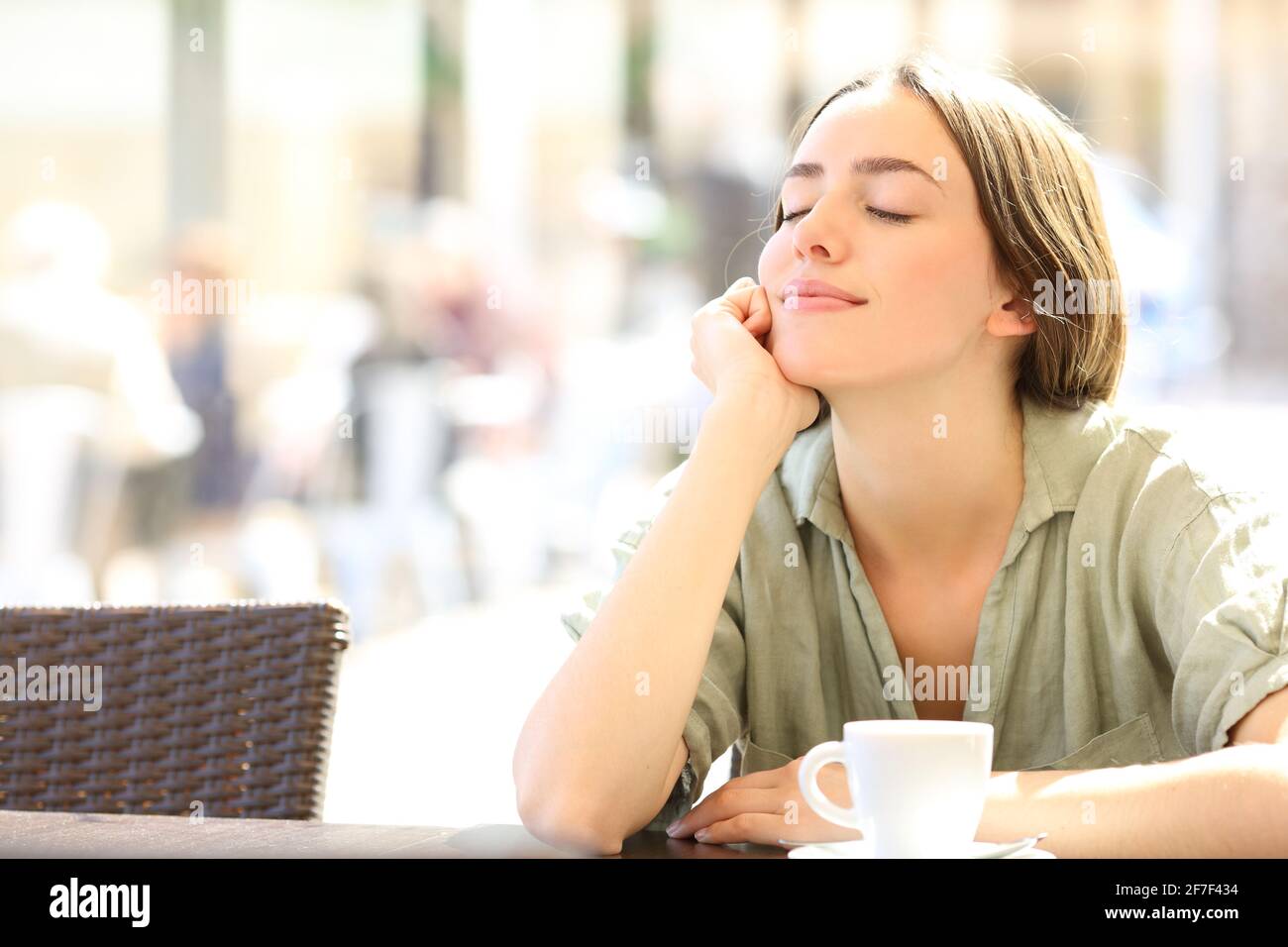Happy woman relaxing with closed eyes sitting in a coffee shop Stock Photo