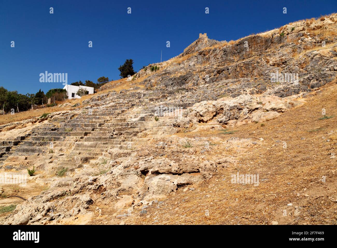 Seating in the ancient theatre at the foot of the Lindian Acropolis in Lindos, on Rhodes, Greece. The venue was used as a place of entertainment. Stock Photo