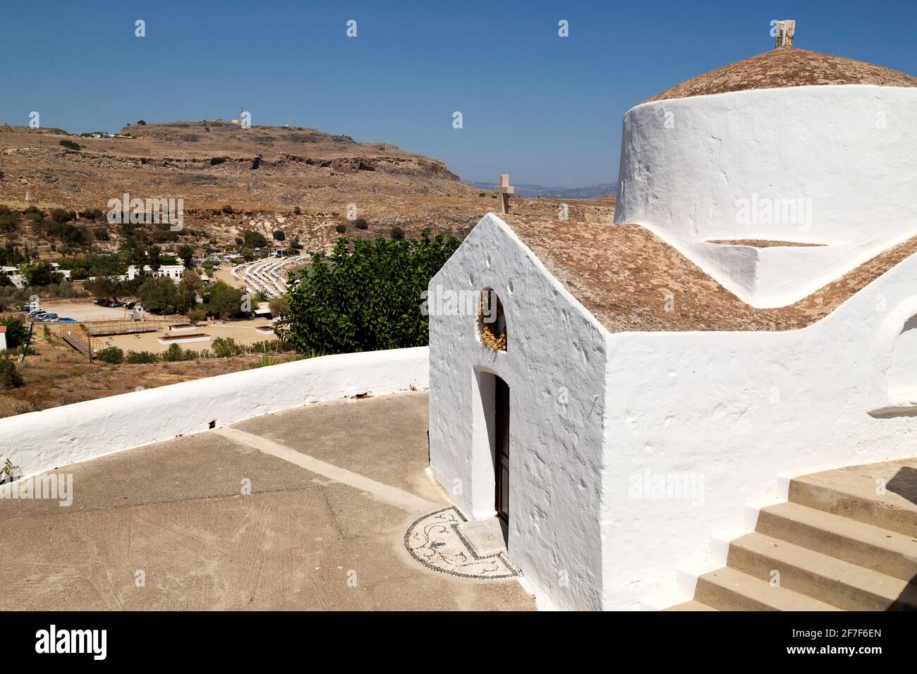 The Chapel of Saint George Pachymachiotis in Lindos on Rhodes, Greece. The white Greek Orthodox chapel is seen under a clear blue sky. Stock Photo