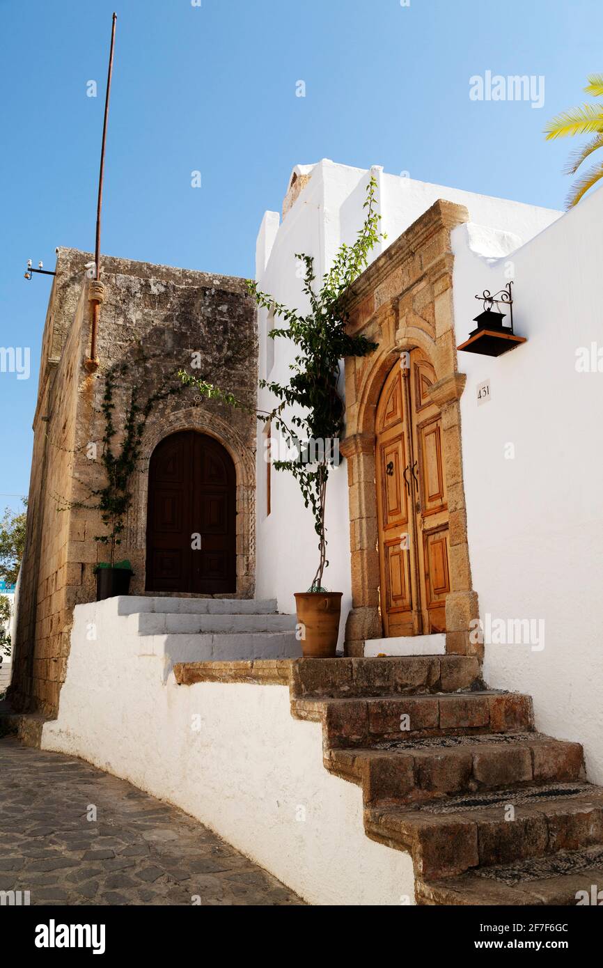 Arched wood doors leading into traditional captain's houses in Lindos on Rhodes, Greece. The houses were built for wealthy sea captains. Stock Photo
