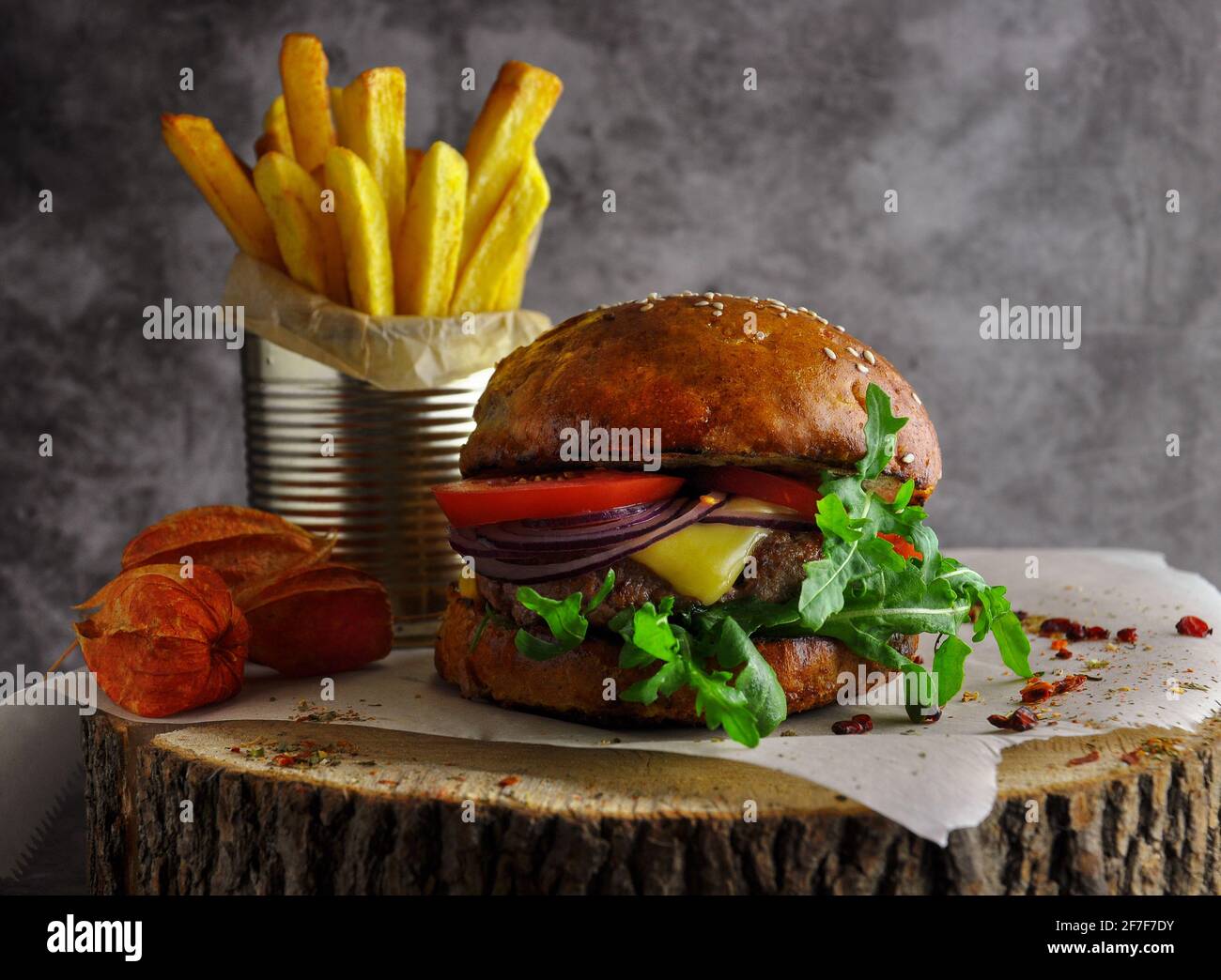 Craft beef burger and fries on a wooden table on a dark background. Stock Photo