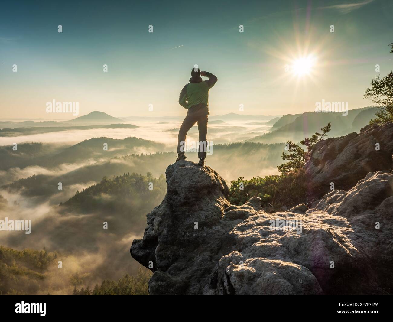 Man enjoy the mountain look. Alone single tourist watching the stunning view ofwhite mist in valley Stock Photo