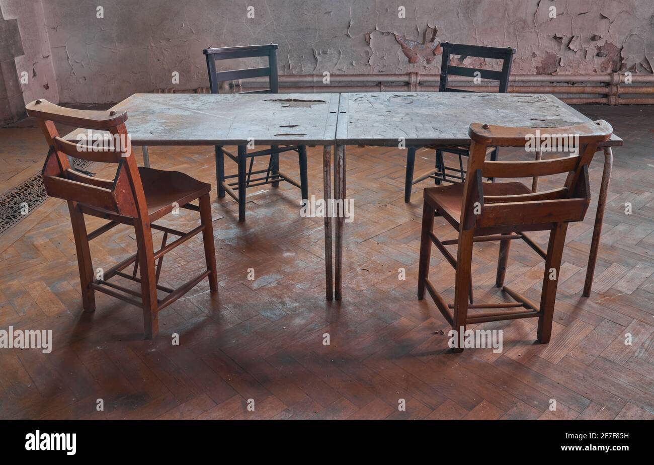 Abandoned grade 2 listed church and the echoing reminiscence of so many meetings and lost conversations that were held over these table and chairs Stock Photo