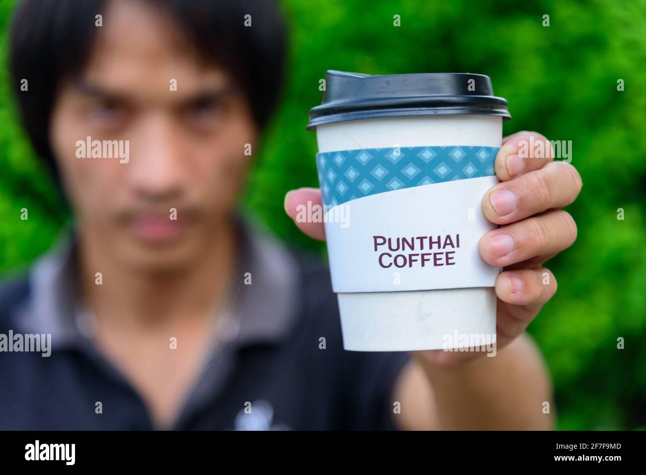 Bangkok,Thailand - 6 April, 2021: The man hold the paper cup of Punthai coffee Stock Photo