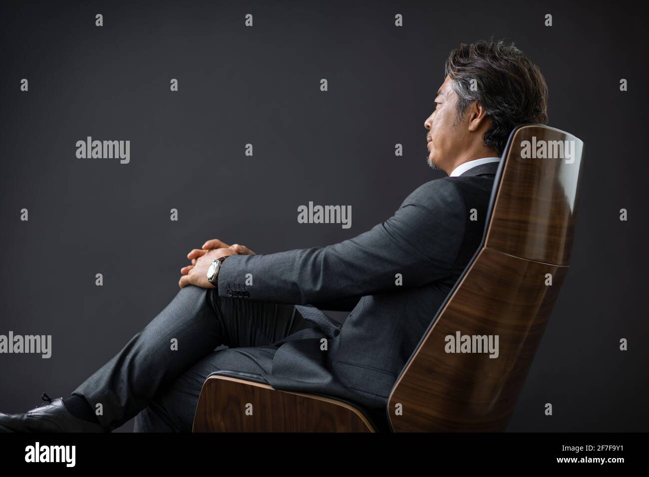 Confident businessman sitting on chair Stock Photo - Alamy